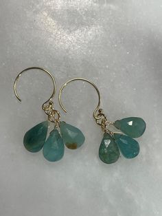 Hand made natural green grandidierite dangle earrings. Turquoise, ocean colors. Made with gold filled ear wires and findings. Measure 1.25" long.  Light catches the stones beautifully, each piece is unique.  Gold filled findings have a 5% real gold layer mechanically bonded to a base metal, and are very durable if taken care of. I include rubber earring stoppers with all earrings. I ship within 3 business days, transit is generally 3-5 business days. Please message me if you need your items by a Turquoise Apatite Gemstone Earrings, Dangle Earrings With Amazonite And Natural Stones, Turquoise 14k Gold-filled Earrings With Ear Wire, Turquoise Dangle Earrings With Amazonite, Turquoise Amazonite Dangle Earrings, Apatite Dangle Earrings With Natural Stones, Handmade Dangle Amazonite Earrings, Handmade Amazonite Dangle Earrings, Turquoise Gemstone Earrings