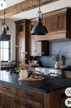 a large kitchen with wooden cabinets and black counter tops, along with an island in the middle