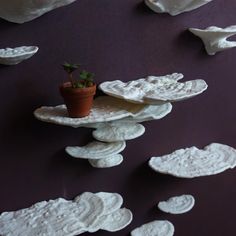 a potted plant sitting on top of a pile of white paper mache shapes