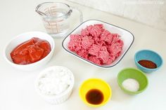 the ingredients to make meatballs are displayed in bowls and measuring cups on a counter