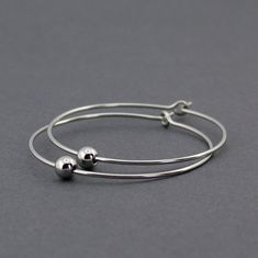 Handmade, minimalist hoop earrings. ‣ handmade, polished earring hoops with a single, 4 mm bead on each hoop ‣ material: 316L stainless steel ‣ size: hoop ⌀: 1.3" / 3.3 cm Minimalist Hypoallergenic Dangle Hoop Earrings, Minimalist Nickel-free Hoop Earrings, Minimalist Hypoallergenic Round Hoop Earrings, Minimalist Hypoallergenic Circle Hoop Earrings, Simple Hypoallergenic Dangle Hoop Earrings, Minimalist Hypoallergenic Hoop Earrings, Simple Small Adjustable Hoop Earrings, Minimalist Adjustable Hoop Jewelry, Simple Adjustable Small Hoop Jewelry