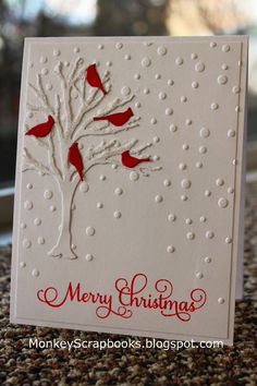 a white card with red birds on it and the words merry christmas written on it