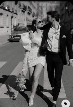 a man and woman walking across a cross walk