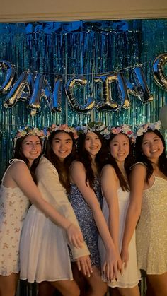 a group of young women standing next to each other in front of a sign that says dance