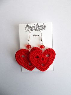 two crocheted heart shaped earrings with red beads