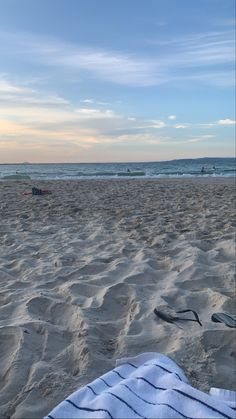 a towel and flip flops are on the beach