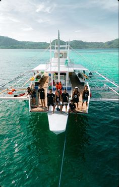 a group of people standing on the back of a boat