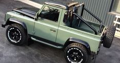 a green pick up truck parked in front of a building