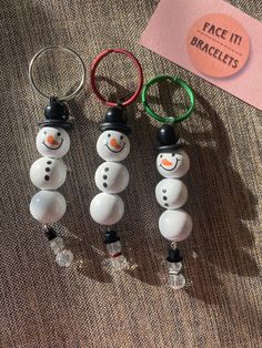 three snowman keychains sitting next to each other on top of a table