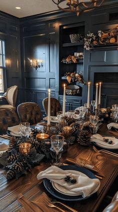 a dining room table is set with candles and place settings