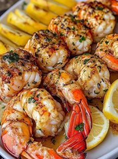 grilled shrimp with lemon wedges and parsley on a white platter, ready to be served