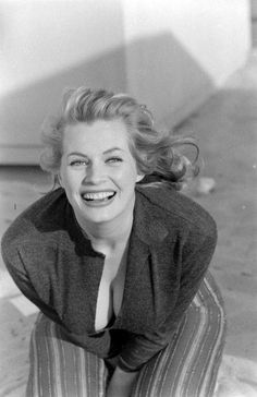 an old black and white photo of a woman smiling