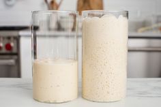 two glasses filled with liquid sitting on top of a counter