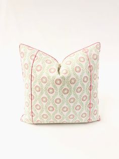 a pink and green decorative pillow on a white background