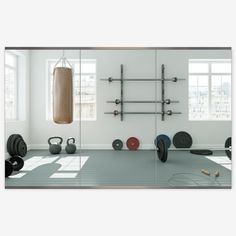 there is a gym with exercise equipment in the room and mirrors on the wall above it