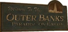 there is a sign that says outer banks paradise on earth in english and arabic letters