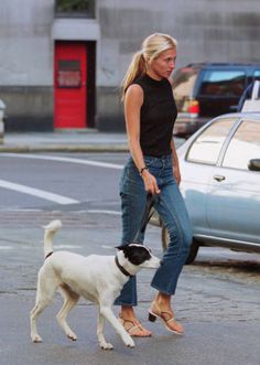 a woman walking her dog across the street