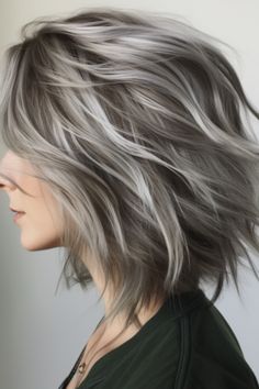 Embrace a modern hairstyle with choppy layers adorned with silver streaks. The uneven layers create texture. Click here to check out more flattering medium-length haircuts for women over 40. Grey Mid Length Hair Styles, Grey Blonde Blending Highlights, Shoulder Length Grey Hairstyles, Silver Hair Lowlights, Silver Streaks In Brown Hair, Haircolour Ideas Short Hair, Low Lights Grey Blending, Gray Hair Shoulder Length, Medium Length Grey Hair With Layers