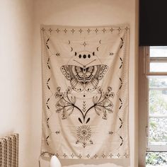 a tapestry hanging on the wall above a bed