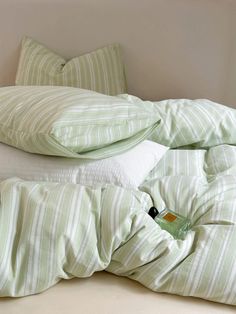 a pile of pillows sitting next to each other on top of a white bed cover