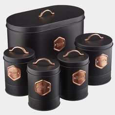 four black and copper canisters with the words home & garden essentials