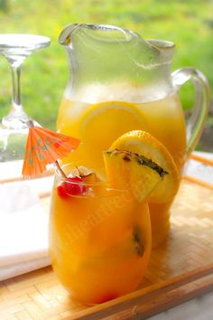 a pitcher and two glasses filled with lemonade sit on a cutting board next to each other