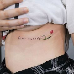 a woman's stomach with the words love yourself tattooed on her lower side ribcage