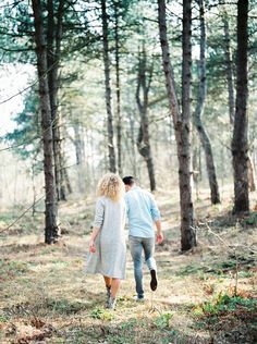 a man and woman walking through the woods