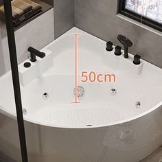 a bathtub with measurements for the size and width in front of a large window