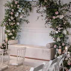 a room with white chairs and flowers on the wall