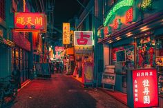 an alley way with neon signs and bicycles parked on the side of it at night