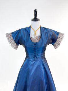 "A fabulous vintage dress from the 1950s! Crisp rayon 'sharkskin' taffeta in the prettiest shade of shimmering blue. Sweetheart bodice tightly fitted through waist and full, flirty a-line skirt. Sweetheart neckline with pale pinky-nudedetail with finely pleated tulle overlay. Matching copped jacketed with small collar, plunging neckline and covered button closure. Dress can be worn strapless-straps button on inside of front bodice so they can be tucked away if not needed. No labels present. Meta 1950s Style Fitted Party Petticoat, Blue Fitted Petticoat For Party, Fitted Blue Vintage Dress For Costume Party, Blue Fitted Vintage Dress For Vintage Occasions, Blue Vintage Dress For Party, Blue Vintage Party Dress, 1950s Blue Evening Dress, 1950s Style Blue Evening Dress, Blue 1950s Evening Dress