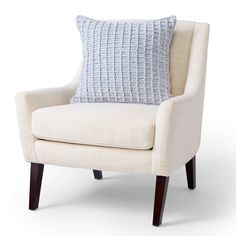 a white chair with a blue pillow on it's back and legs, in front of a white background