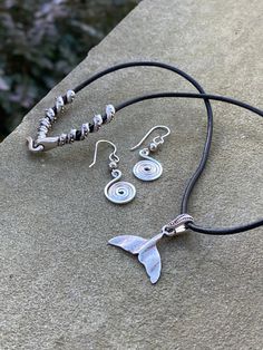 Description Bring out your inner Mermaid with this jewelry that can be purchased individually or as a set. This necklace and earring set is part of The New England Collection and represents the state of Massachusetts. The necklace features a hypoallergenic artisan pewter whale or mermaid tail hung on high quality leather that is US sourced and free of AZO and formaldehyde. The unique swirl clasp is artisan pewter as well. Let me know in the message box at checkout if you need a custom length. Th Symbolic Dangle Jewelry With Ear Wire, Symbolic Metal Jewelry With Matching Earrings, Adjustable Symbolic Spiral Jewelry, Symbolic Adjustable Spiral Jewelry, Adjustable Sterling Silver Jewelry Sets For Gifts, Nickel-free Spiral Metal Jewelry, Symbolic Silver Jewelry With Matching Earrings, Adjustable Spiral Nickel-free Jewelry, Handmade Adjustable Sterling Silver Jewelry Set