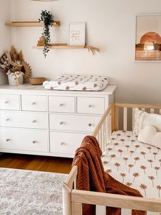 a baby's bed and dresser in a room