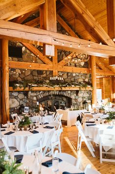 tables and chairs are set up for a wedding reception in a rustic setting with stone fireplace