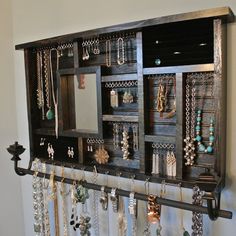 a wall mounted jewelry rack with many necklaces and earrings hanging from it's sides