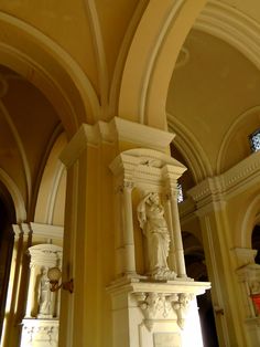 a statue in the middle of a room with arches