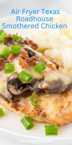 a white plate topped with chicken covered in sauce and green onions next to mashed potatoes