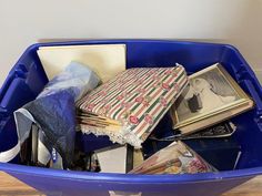 a blue trash can filled with books and magazines