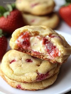 two strawberry shortbread cookies stacked on top of each other with one bite taken out