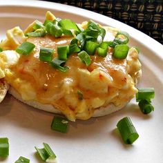 an omelet with green onions on a white plate