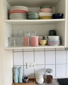 the shelves in the kitchen are filled with dishes