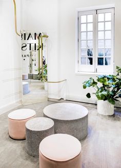 three stools are in the middle of a room with white walls and flooring