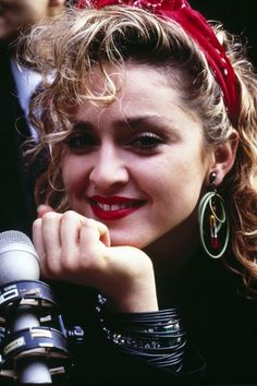 a close up of a person with a smile on her face and wearing large hoop earrings