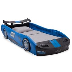 a blue race car bed with wheels on the sides and numbers painted on the side