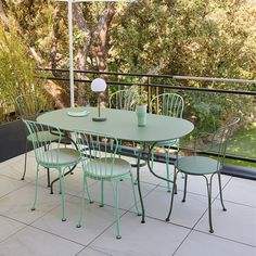 an outdoor table and chairs on a patio with trees in the backgroung