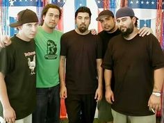 four men are standing together in front of an american flag