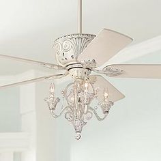 a white ceiling fan with crystal chandelier hanging from it's blades in a bedroom