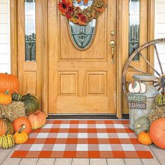 pumpkins and gourds are sitting on the front porch with hay bales